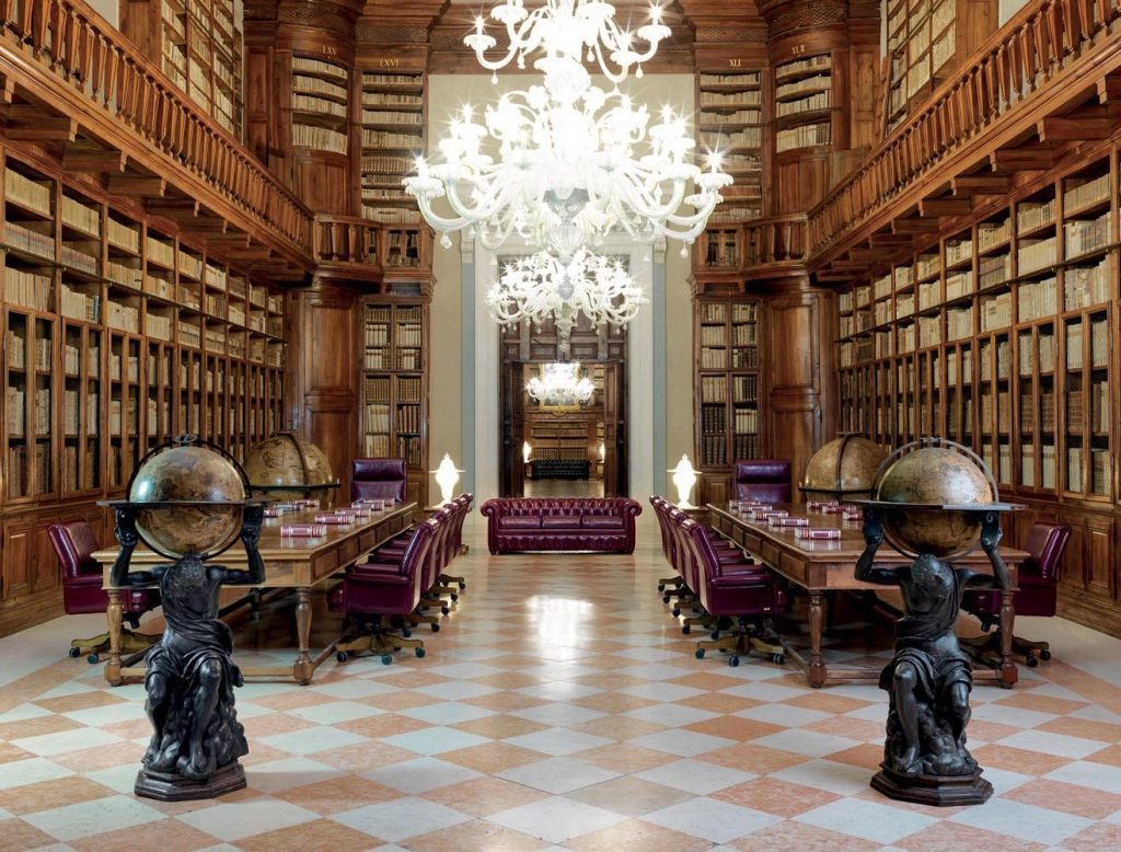 Biblioteca elegante con globi e lampadari.